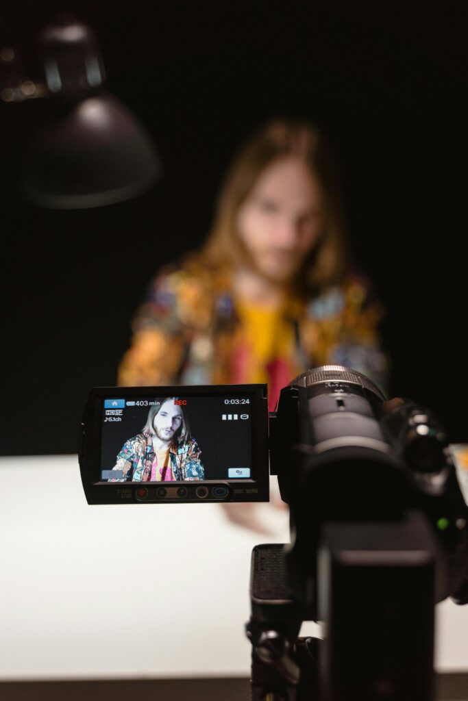A vlogger recording a video using a professional camera setup indoors.